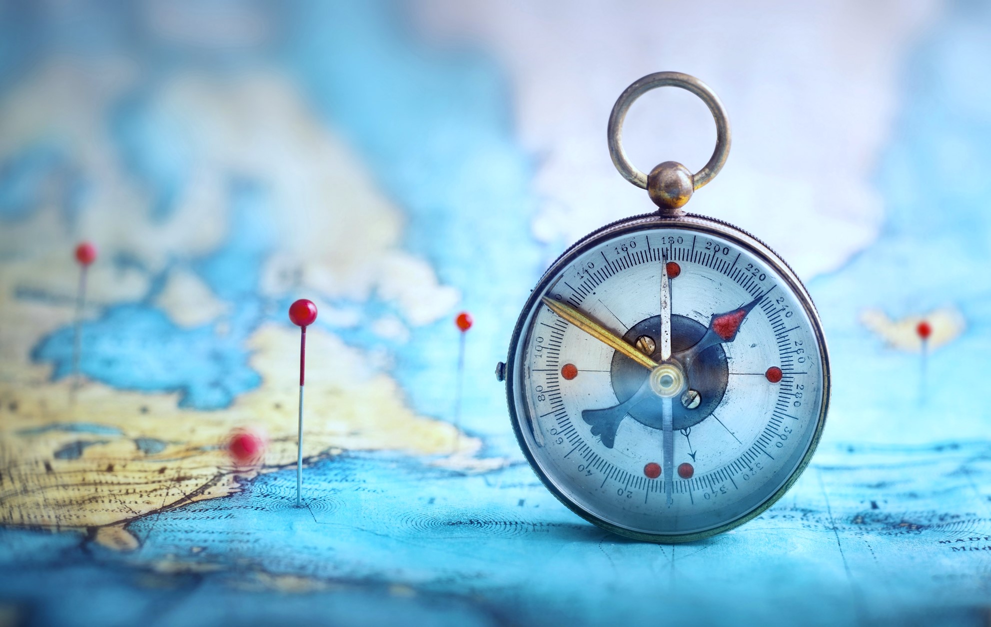 compass on a map with pins in it